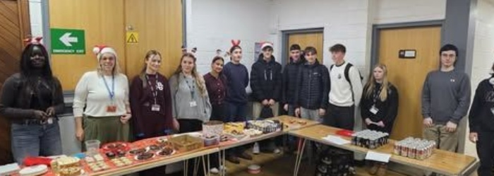 Lipson Students stading behin tables at their bake sale